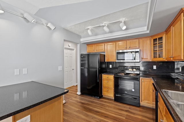 kitchen featuring decorative backsplash, dark countertops, glass insert cabinets, dark wood-style floors, and black appliances