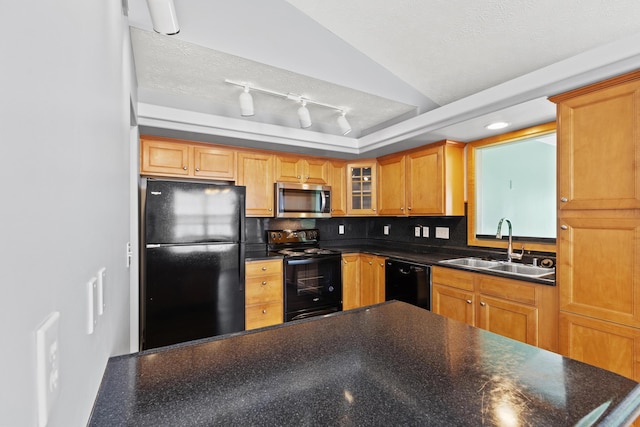 kitchen with dark countertops, glass insert cabinets, a textured ceiling, a sink, and black appliances