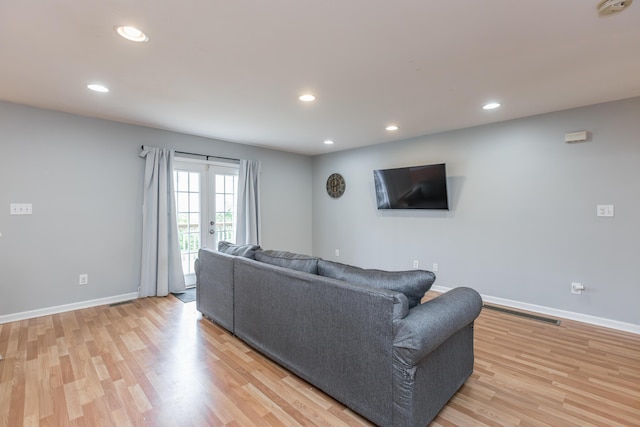 living room with baseboards, recessed lighting, and light wood-style flooring