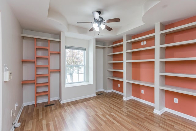 interior space featuring visible vents, a ceiling fan, baseboards, and wood finished floors