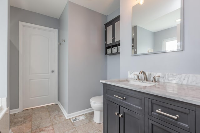 bathroom with baseboards, vanity, toilet, and visible vents