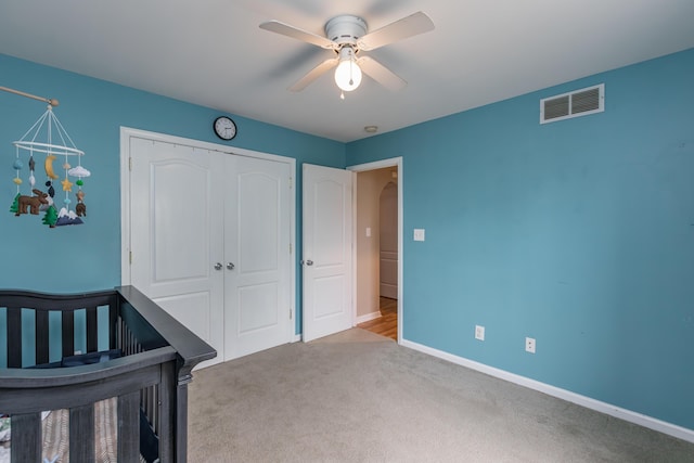 unfurnished bedroom with carpet, a ceiling fan, baseboards, visible vents, and a closet