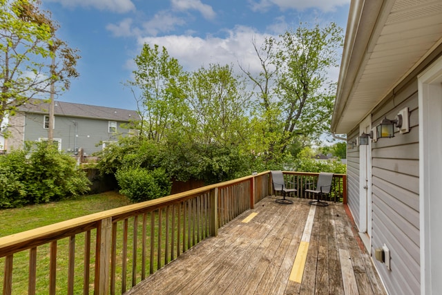 wooden terrace featuring a lawn