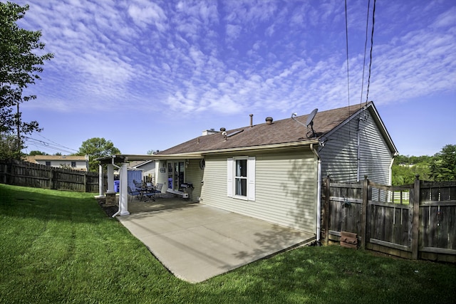 back of house featuring a lawn, a fenced backyard, and a patio area