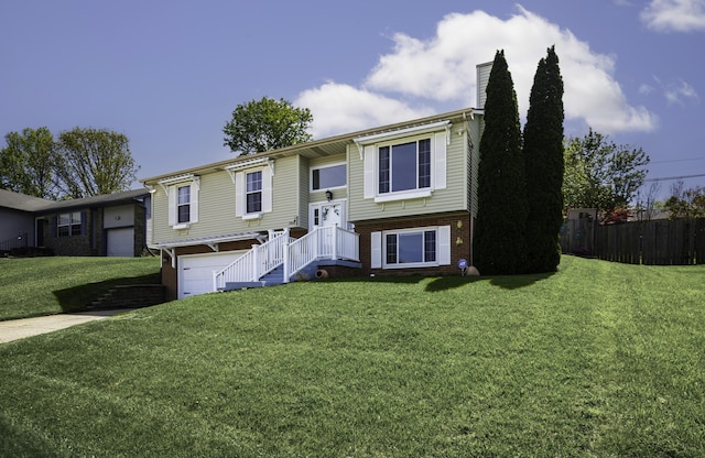 bi-level home with brick siding, a front lawn, an attached garage, and a chimney