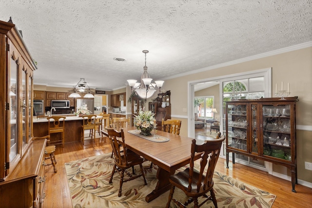 223 Lanetown Rd, Nancy, KY 42544 - dining space featuring an inviting chandelier, ornamental molding, light wood-style floors, and a textured ceiling