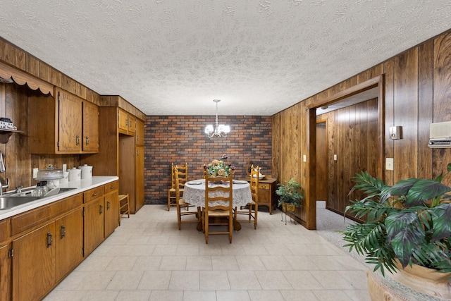 223 Lanetown Rd, Nancy, KY 42544 - dining area featuring an inviting chandelier, wood walls, a textured ceiling, and brick wall