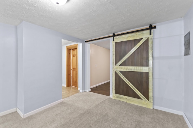 30 Wheeler St, South Shore, KY 41175 - unfurnished bedroom with carpet floors, a textured ceiling, baseboards, and a barn door