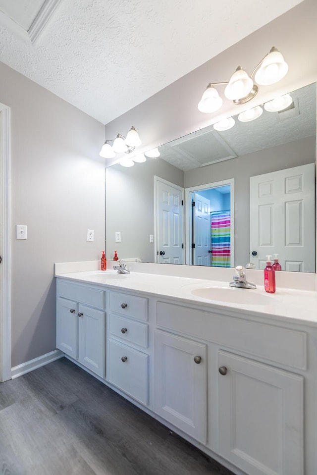 full bathroom featuring double vanity, a sink, and wood finished floors