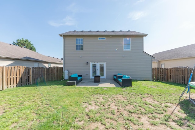 back of property with a patio, a fenced backyard, a lawn, and french doors