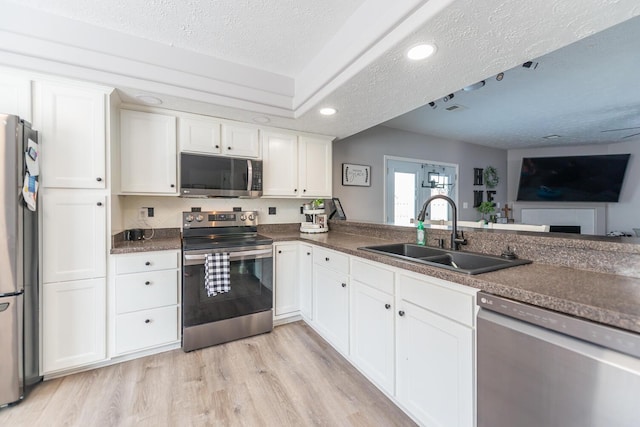 kitchen featuring a sink, white cabinets, stainless steel appliances, and a textured ceiling