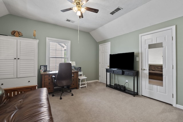 office area with visible vents, ceiling fan, vaulted ceiling, and light colored carpet