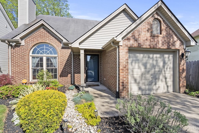view of front facade featuring fence, a chimney, brick siding, an attached garage, and driveway