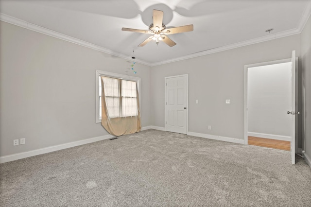 spare room featuring crown molding, baseboards, ceiling fan, and carpet flooring