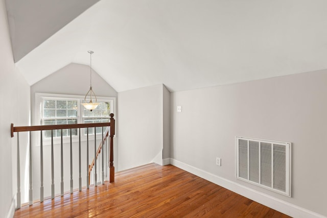 bonus room with baseboards, visible vents, wood finished floors, and lofted ceiling