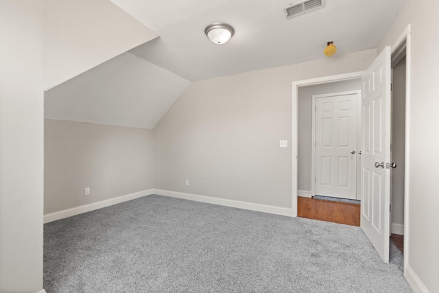 additional living space featuring vaulted ceiling, baseboards, carpet flooring, and visible vents