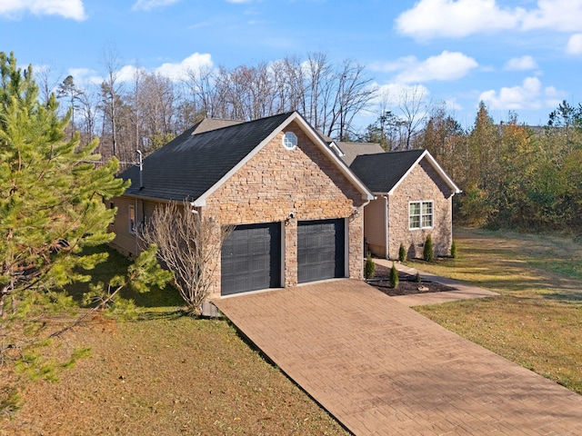 view of front of home with a garage, a front yard, decorative driveway, and stone siding