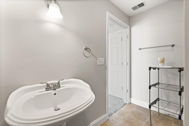 bathroom featuring a sink, baseboards, and visible vents