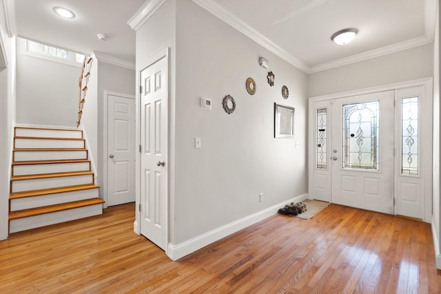 foyer with baseboards, ornamental molding, stairs, and light wood-style flooring