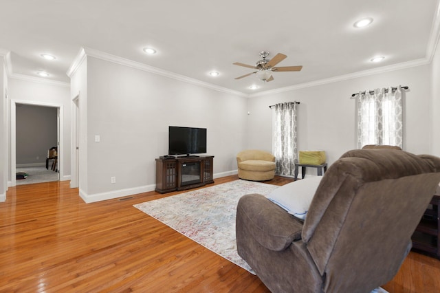 living area with ceiling fan, crown molding, baseboards, light wood-style floors, and recessed lighting