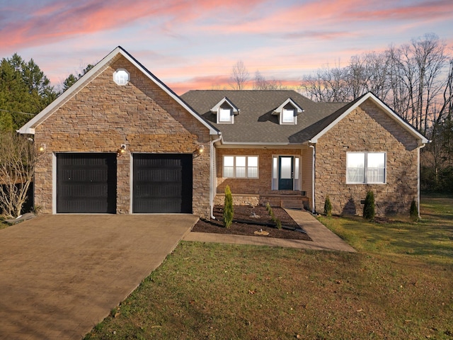 traditional home featuring an attached garage, a yard, stone siding, and concrete driveway