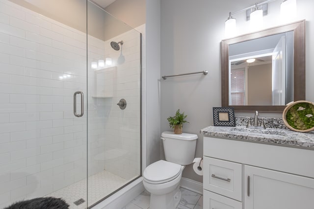 full bathroom with a stall shower, vanity, baseboards, toilet, and marble finish floor