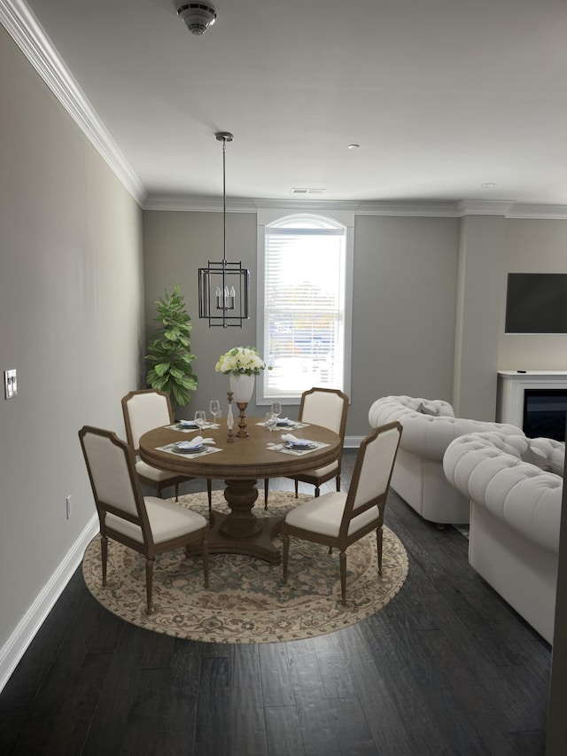 dining room featuring baseboards, ornamental molding, dark wood-style flooring, and visible vents
