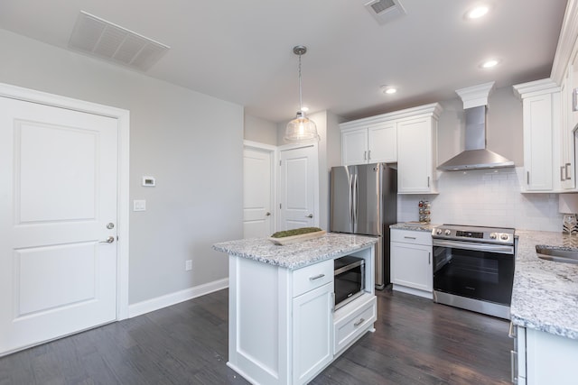 kitchen featuring visible vents, appliances with stainless steel finishes, white cabinets, and wall chimney range hood