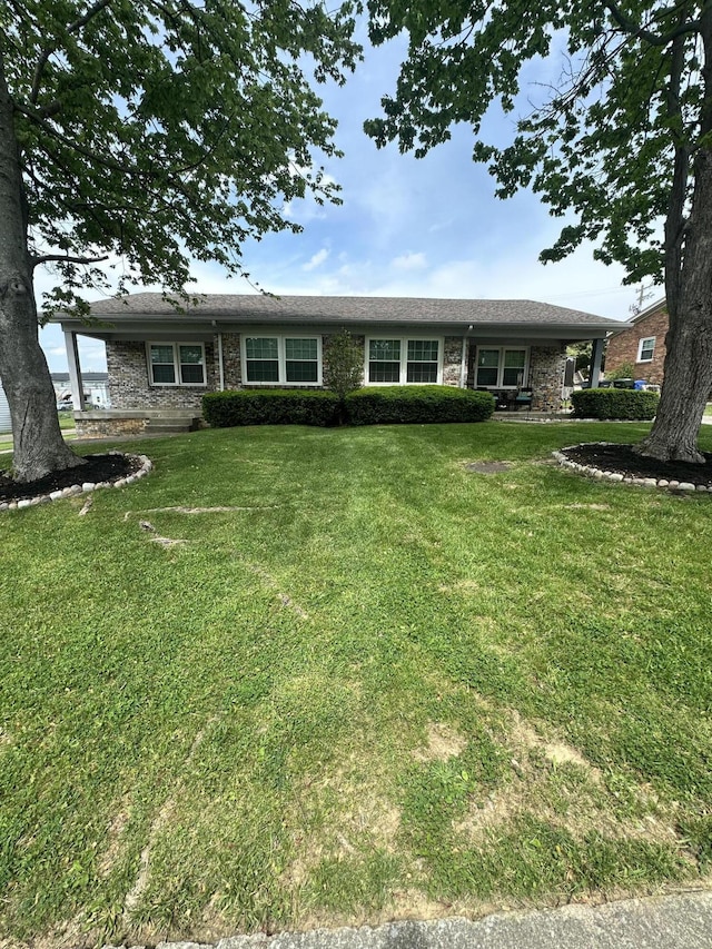 ranch-style house featuring brick siding and a front yard