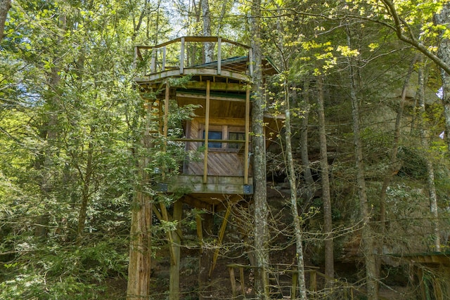 view of property exterior with a wooded view