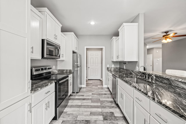 1620 Hannah Dr, Lawrenceburg, KY 40342 - kitchen featuring white cabinets, stainless steel appliances, a sink, and dark stone counters