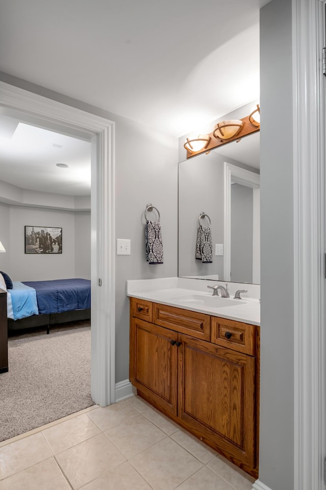 ensuite bathroom featuring connected bathroom, baseboards, tile patterned flooring, and vanity