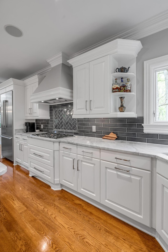 kitchen with white cabinetry, appliances with stainless steel finishes, and custom exhaust hood