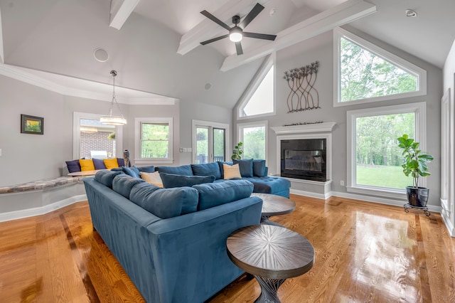 living area featuring baseboards, high vaulted ceiling, beam ceiling, and light wood-style flooring