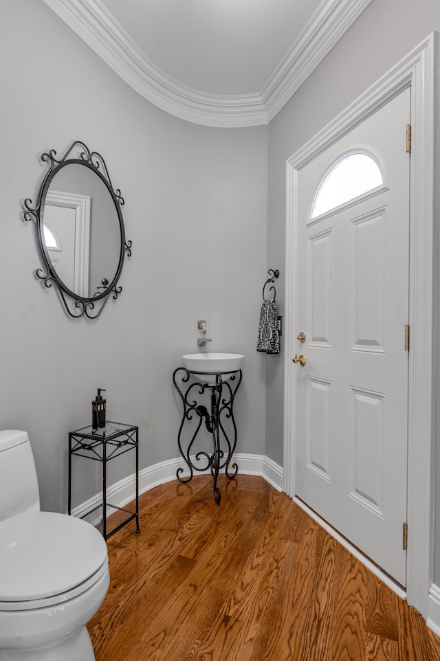 foyer entrance featuring baseboards, ornamental molding, and wood finished floors