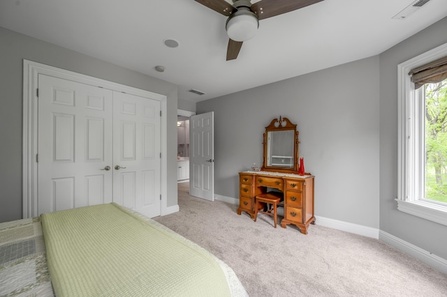 bedroom featuring light colored carpet, baseboards, visible vents, and a closet