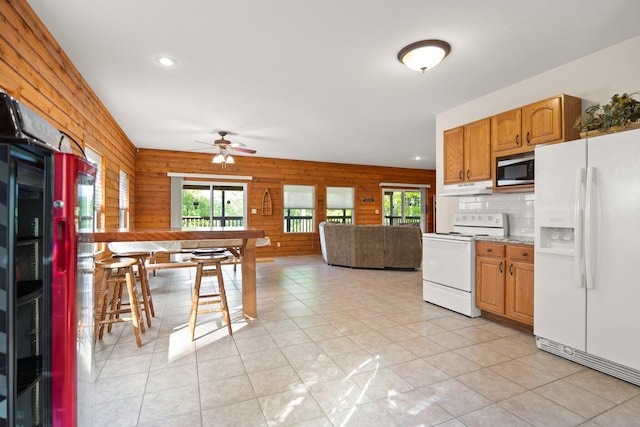kitchen featuring white appliances, wooden walls, recessed lighting, under cabinet range hood, and a ceiling fan