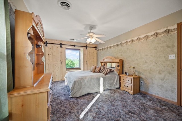 bedroom with ceiling fan, carpet, a barn door, and visible vents