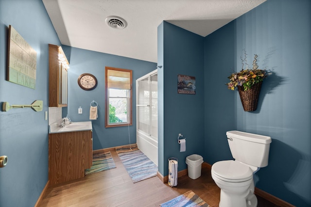 full bath with visible vents, vanity, wood finished floors, toilet, and baseboards