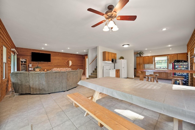 dining space with a ceiling fan, wood walls, light tile patterned floors, and recessed lighting