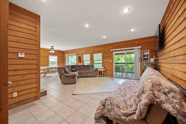 living area with recessed lighting, a ceiling fan, wood walls, and light tile patterned flooring