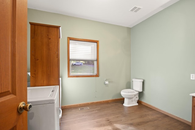 bathroom featuring visible vents, washer / clothes dryer, wood finished floors, and vanity