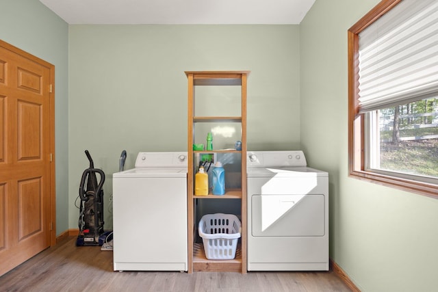 washroom with independent washer and dryer, laundry area, baseboards, and wood finished floors