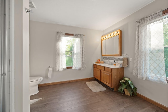 full bath featuring visible vents, baseboards, wood finished floors, and vanity