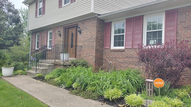 view of exterior entry featuring brick siding