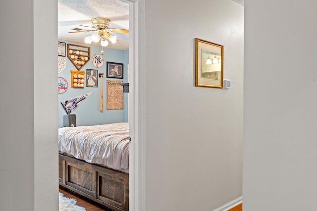 hall featuring a textured ceiling and wood finished floors