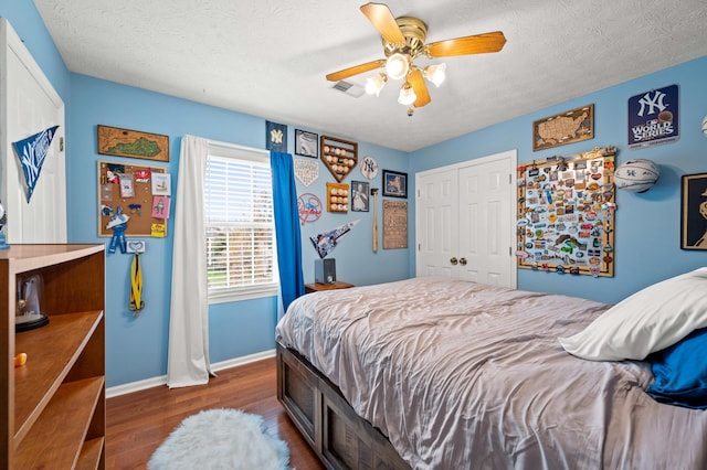 bedroom with ceiling fan, visible vents, baseboards, a closet, and dark wood-style floors