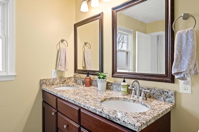 full bathroom featuring a sink and double vanity