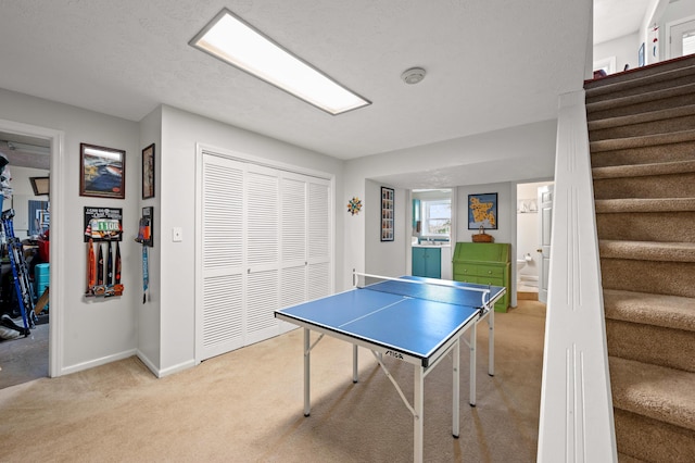 rec room with baseboards and light colored carpet