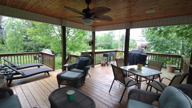 wooden terrace with a ceiling fan and outdoor dining area